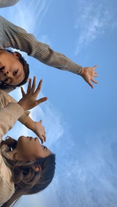 three people reaching up into the air with their hands