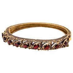 Vintage 14K Yellow Gold Garnet Bangle Bracelet - The bracelet contains 9 oval garnets that measure 6 x 4mm. The width of the bangle is 8.5mm and tapers down to 5mm and has oxidation on the side. The bracelet weighs 23.44 grams.