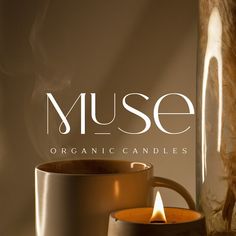 a candle is lit next to a mug with the word muse on it in white