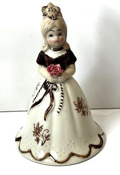 a porcelain figurine with a flower in her hand