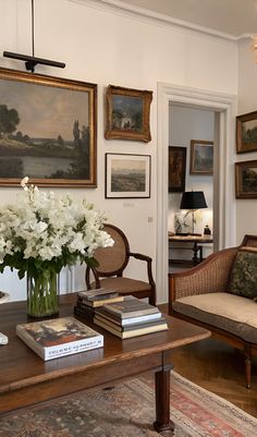 a living room filled with furniture and pictures on the wall above it's coffee table