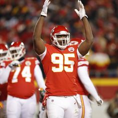 a football player holding his hands up in the air