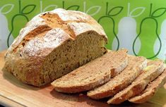 a loaf of bread sitting on top of a cutting board next to slices of bread