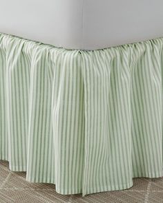 a green and white striped bed skirt with pleated edges