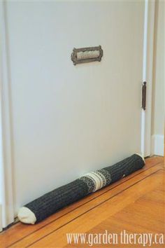 a black and white dog bed on the floor in front of a wall with a door