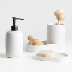 a white bathroom set with soap, brush and soap dispenser on the counter