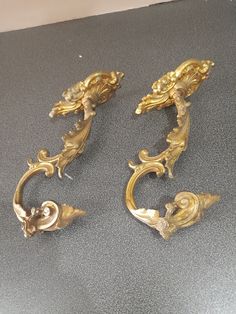 three gold colored metal handles on top of a gray countertop next to each other