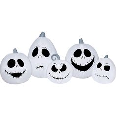 three white pumpkins with faces painted on them, one is black and the other is white