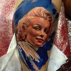 a woman's leg with a blue and white painting on it that says marilyn monroe