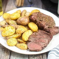 a white plate topped with steak and potatoes