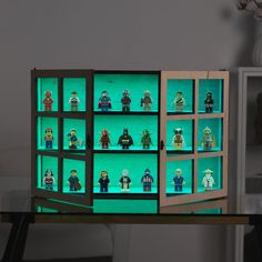 a display case filled with lego minifigures on top of a wooden table