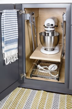 an open cabinet with a mixer and utensils in it