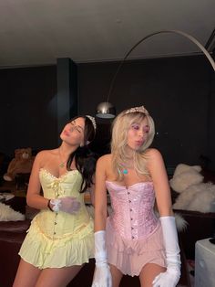 two women dressed in costumes posing for the camera