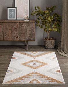 a white rug with an orange and blue design on the floor next to a wooden cabinet