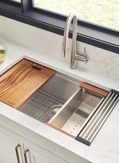 a kitchen sink with a wooden cutting board in it