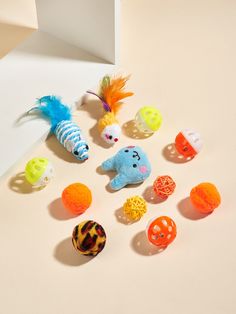 there are many different toy animals on the table next to each other and one has a feather