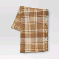 a tan and white plaid blanket on a gray background