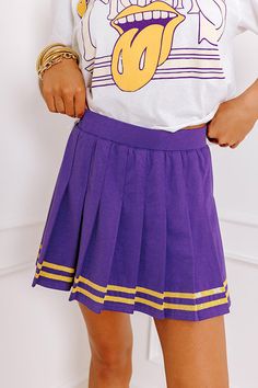 - Cheer on your team in this cute pleated skort! Featuring bold jersey-style accent stripes, it's perfect for showing off a sporty-chic vibe on game day. Crisp pleats make it perfect for letting your team spirit shine. Rally your friends and get ready to celebrate in style with this adorable piece. - Stretchy pleated material - Built-in stretchy shorts - An elastic waistline - Jersey-style sequined accent stripes at the bottom of the skirt - A flattering silhouette that ends in a pleated upper-t Preppy Mini Tennis Skirt For School, Sporty Spring Skort For School, Casual Purple Pleated Bottoms, Purple Pleated Mini Tennis Skirt, Sporty Pleated Skort For School, Sporty Mini Tennis Skirt For School, Casual Purple Pleated Mini Skirt, Sporty Purple Tennis Skirt, Purple Pleated Tennis Skirt For Summer