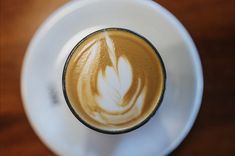 a cappuccino in a white cup on a wooden table