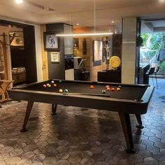 a pool table is in the middle of a room with several other items on it