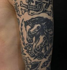 a man with a skull and horse tattoo on his arm next to another person's stomach