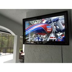 a television mounted to the side of a wall with a motorcycle on it's screen