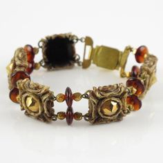 Henry Perichon, a French jewelry designer, created this stunning resin link bracelet adorned with amber-colored glass beads and metallic stones. He revolutionized the plastic jewelry industry with his "rhodoid" invention,  which he extensively used to craft his innovative jewelry. The scored resin setting produces extraordinary examples of costume jewelry, and the bracelet is signed "Henry" on a small gilt metal tag at the clasp. Measurements: The bracelet's total length is 8.87 in (22.5 cm) - w Vintage Polished Bead Bracelet, Vintage Polished Beads Bracelet, Vintage Polished Beads Bracelet Jewelry, Gold Resin Bracelet, Vintage Amber Resin Jewelry, Elegant Brown Metal Beaded Bracelets, Brown Bakelite Jewelry As A Gift, Brown Bakelite Jewelry Gift, Vintage Gold Czech Glass Bracelets