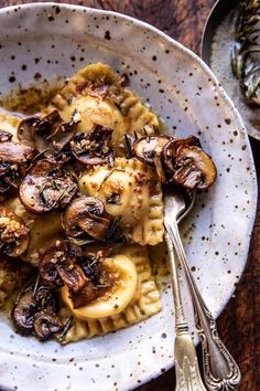 a white plate topped with pasta covered in mushrooms