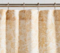 an orange and white curtain hanging from a metal rod