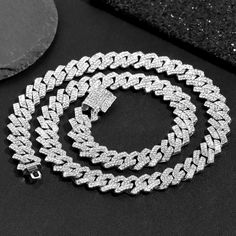 Rhinestone Cuban Link Chain Necklace Set is a stunning and glamorous jewelry set that will elevate your style and make a bold statement. This set features a dazzling necklace adorned with clustered rhinestones in a Cuban link design. The necklace is crafted with high-quality materials, ensuring durability and long-lasting shine. The clustered rhinestones catch the light beautifully, adding a touch of sparkle and elegance to any outfit. Whether you're attending a special occasion, a party, or sim Iced Out Crystal Chain Link Jewelry, Silver Diamond Cuban Link Necklace With Bling, Dazzling Cubic Zirconia Chain Necklaces, Dazzling Cubic Zirconia Chain Necklace, Iced-out Chain Link Necklace In Diamond White, Iced Out Diamond White Chain Link Necklace, Silver Cuban Link Bling Necklace, Silver Rhinestone Cuban Link Necklace, Silver Cuban Link Chain Necklace With Rhinestones