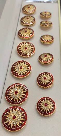 many red and gold buttons on a white surface