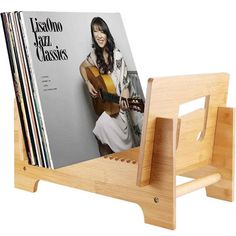 a wooden magazine rack with a guitar and magazines on it's sides, in front of a white background