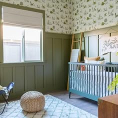 a baby's room with green walls and floral wallpaper