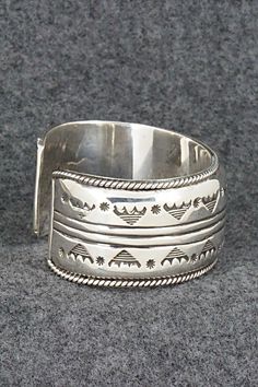 This stunning and substantial sterling silver bracelet was made by Navajo silversmith Emerson Delgarito. The inside is signed E. Delgarito.Size: 5 1/2" (will fit up to a 6 3/8" wrist)Gap: 7/8"Length: 1 1/8"Free shipping on all orders! We ship with USPS and always include tracking. All orders ship within a day of payment.Returns are accepted up to 30 days after you receive your order. Just send us a message. Our shop offers cash back or store credit. The item must be returned in new condition. Southwestern Style Polished Bangle, Southwestern Style Silver Round Cuff Bracelet, Southwestern Silver Cuff Bracelet, Untreated Sterling Silver Bracelet, Silver Untreated Cuff Bracelet Gift, Silver Artisan Bracelet, Sterling Silver Wide Band Bracelet, Artisan Silver Cuff Bracelet With Inlay, Artisan Silver Bracelets With Inlay