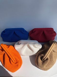 four purses lined up on top of each other in different colors and sizes,