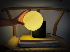 a person is holding the light on top of some books