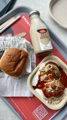 a tray that has some food on it and a bottle of coffee next to it