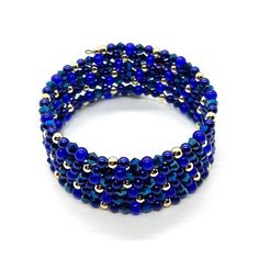 Blue and Gold Sparkle Memory Wire Bracelet You are sure to sparkle with this beautiful, handcrafted beaded bracelet!  There are six beaded strands displayed in a continuous pattern.  The bracelet is made of a variety of glass beads and high-quality 14K gold-plated beads. It features 2.4" diameter stainless steel bracelet memory wire in a dark antique finish. Memory wire provides easy application and removal. There are no complicated clasps and one size fits most.  This bracelet makes a perfect gift for friends or loved ones. The bracelet will be packaged in a gift box.   Beads included:  3mm & 4mm 14K Gold Plated Beads (These are high-quality, thick, gold-plated beads with a nice gloss that makes them hard to fade.)  4mm Royal Blue Glass Pearl Beads 4mm Royal Blue Translucent Glass Round B Continuous Pattern, Translucent Glass, Memory Wire Bracelet, Memory Wire Bracelets, Memory Wire, Wire Bracelet, Gold Sparkle, Antique Finish, Blue And Gold