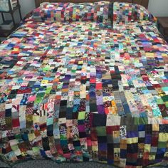 a bed with a large quilt on top of it