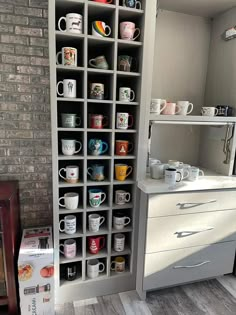 there are many mugs on the shelves in this room, and one is empty