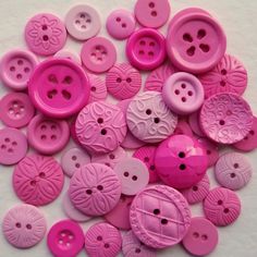 many pink buttons on a white surface