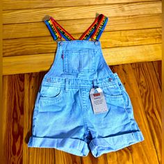 Levi’s Blue Jean Short Overalls With Adjustable Rainbow Straps, Nwt. Size Short Tall 6 Regular Blue Denim Bottoms For Playwear, Casual Light Blue Bottoms For Playtime, Light Blue Casual Bottoms For Playtime, Blue Short Length Summer Overalls, Blue Shortalls With Pockets, Denim Blue Short Length Shortalls, Blue Short Summer Overalls, Levi's Blue Cotton Bottoms, Levi Short Overalls