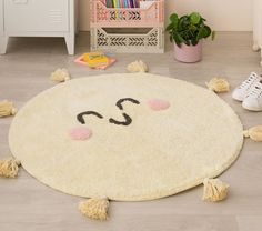 a child's room with a rug that has a smiley face drawn on it