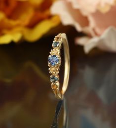 a close up of a ring with flowers in the background