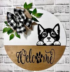 a welcome sign with a black and white cat on it