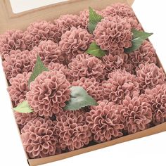 a cardboard box filled with pink flowers and green leaves