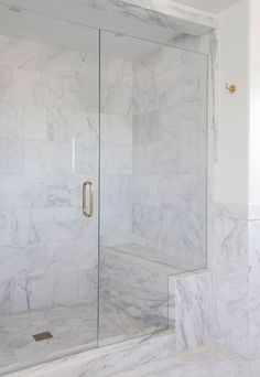 a walk in shower with marble walls and floor