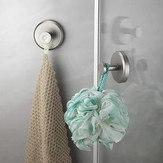 a shower door handle with a towel hanging from it's side and a green flower in the middle