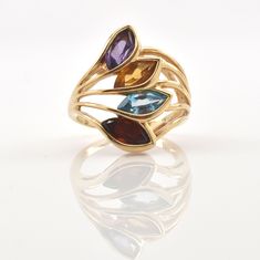 Exquisite 14 karat solid yellow gold ring bezel-set with four marquise-cut gemstones (amethyst, citrine, blue topaz, and garnet), each measuring approximately 7.78 millimeters long by 3.73 millimeters wide and weighing a total of 2.59 carats. The ring is approximately a size 4 1/2, and can be re-sized to fit by your local jeweler. It weighs approximately 5.33 grams. It is stamped 14KP, where the P stands for Plumb, or exactly 14 karat. Excellent estate condition. This ring is a perfect Mother's Yellow Gold Marquise Multi-stone Jewelry, Gold Multi-stone Marquise Cut Jewelry, Gold Marquise Birthstone Ring With Gemstone, Gold Marquise Birthstone Ring, Marquise Cut Multi-stone Yellow Gold Jewelry, Gold Marquise Amethyst Ring, Gold Marquise Amethyst Ring Fine Jewelry, Gold Marquise Amethyst Gemstone Ring, Gold Amethyst Marquise Ring