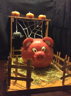 a pumpkin with an animal's head on top of it in front of a fence